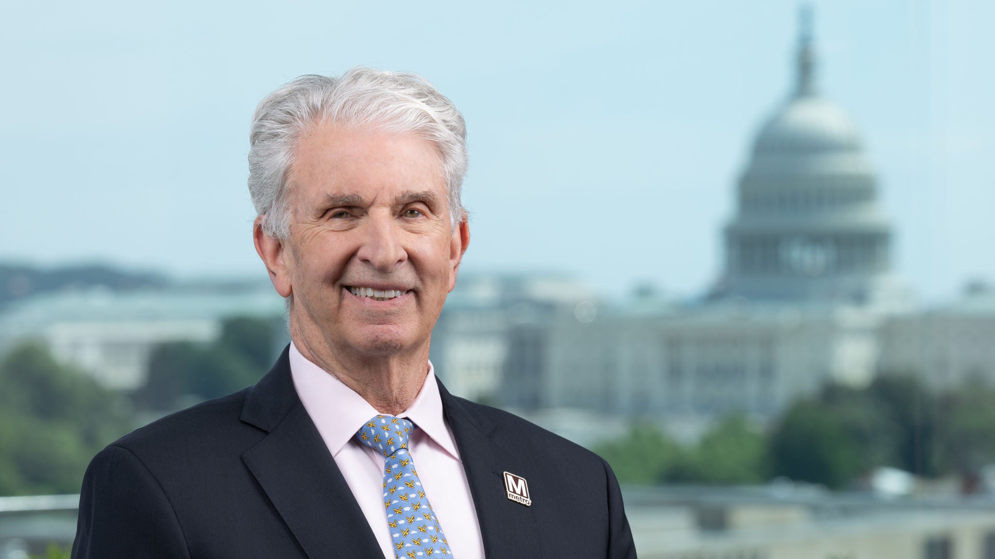 Headshot of Director Mike Goldman earning a black suit with a blue, white, and yellow tie.