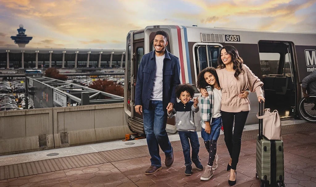 family of 4 in front of a Metro Train
