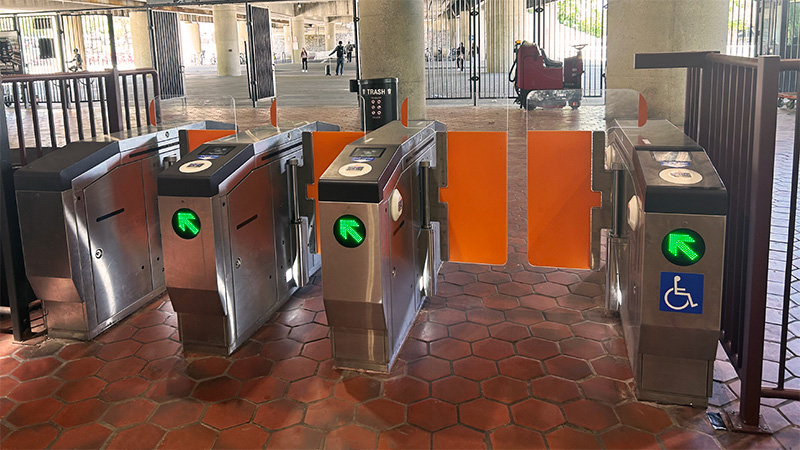 Swing-door-style barrier to deter passengers from climbing over barriers