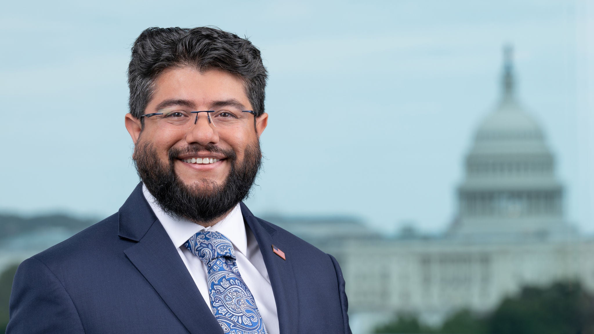 Headshot of Director Canek Aguirre wearing a blue with a blue and grey paisley tie.
