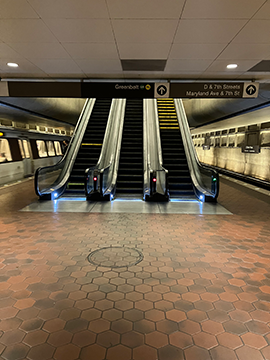 A picture of escalators on the Lower Platform of the L'Enfant Plaza Station. These escalators lead to the Greenbelt side of the Upper Platform.