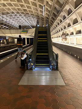 A picture of the escalator from the Branch Avenue/Huntington side of the platform to an elevated mezzanine.